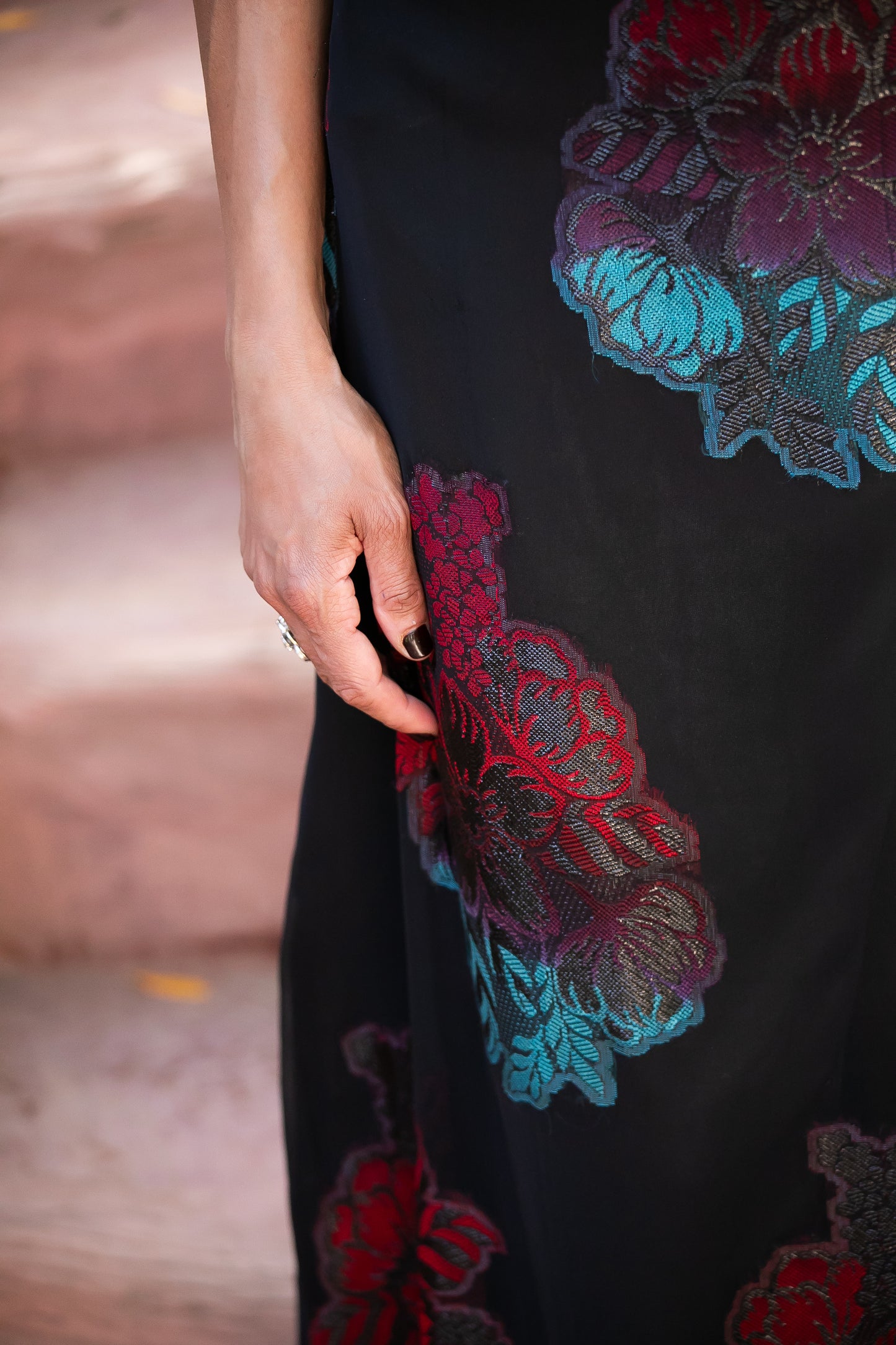 Close-up of embroidered red and teal floral detailing on the Dusky Rose gown, highlighting the intricate craftsmanship