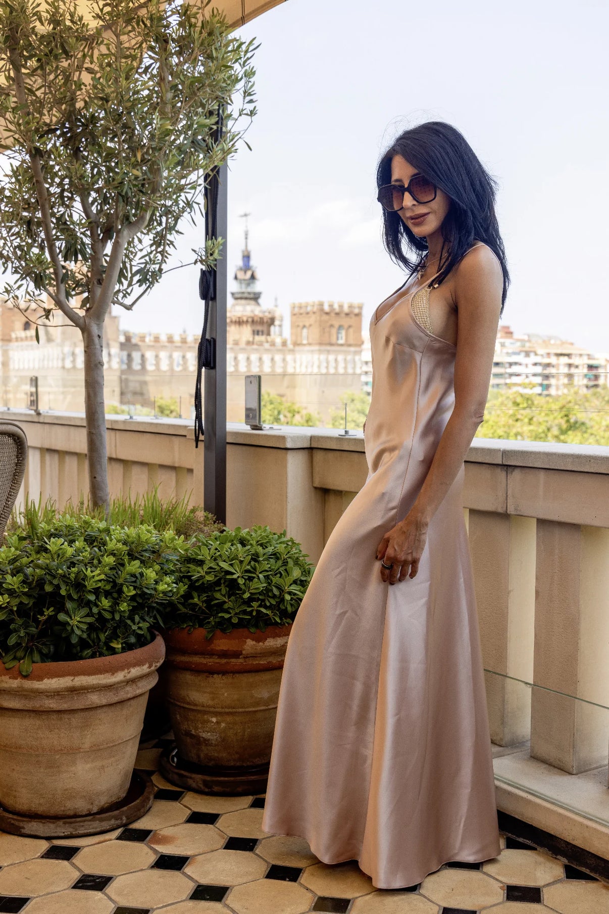 Blush Slip by Preema Aura, full-length blush satin slip dress photographed on a city terrace, luxury occasionwear UK.