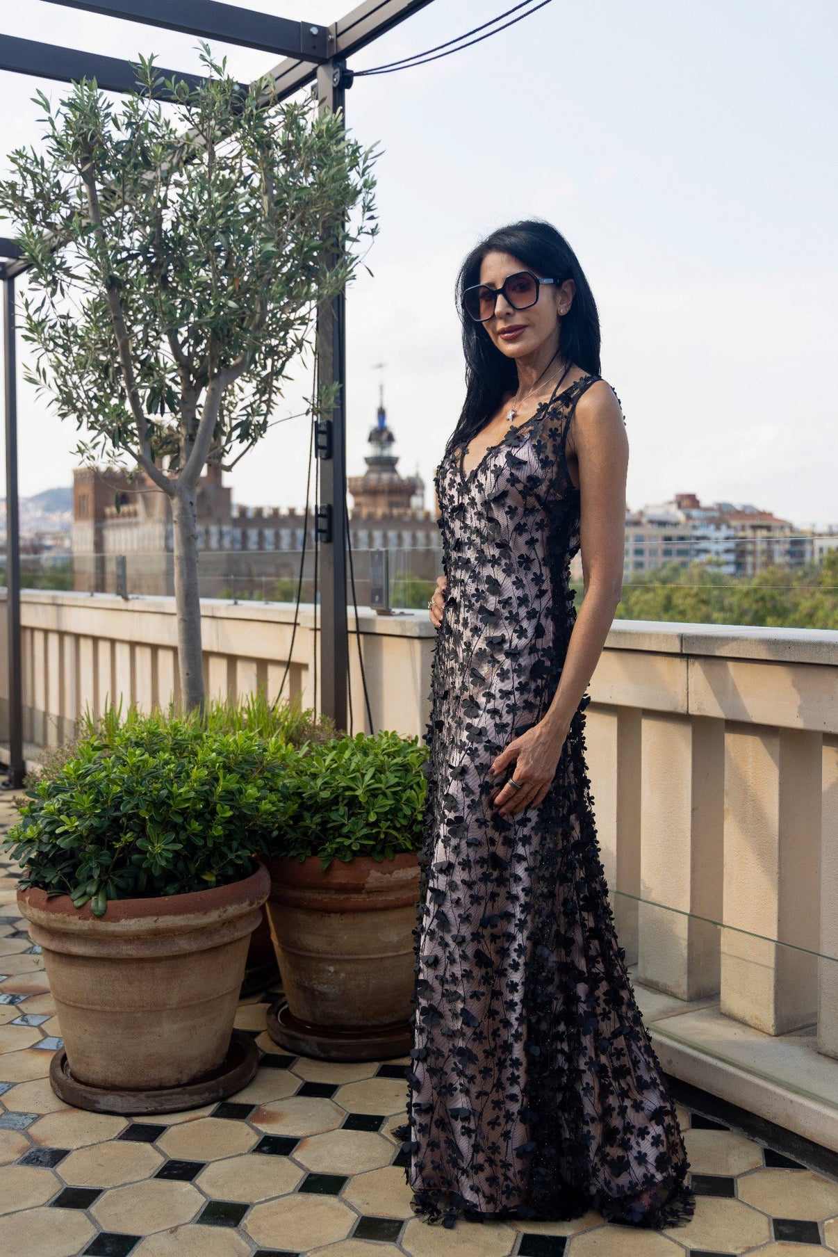 Daisy Noir by Preema Aura layered over a blush satin slip, highlighting the sheer black floral detailing and soft contrast against the city backdrop.