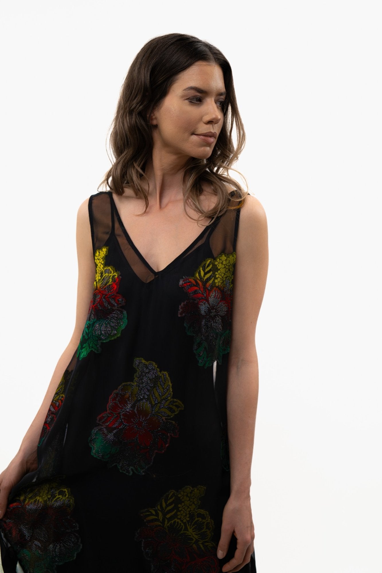 Close-up of the Preema Aura Dusky Rose dress, highlighting the sheer neckline and intricate multicoloured floral detailing against the black French silk.