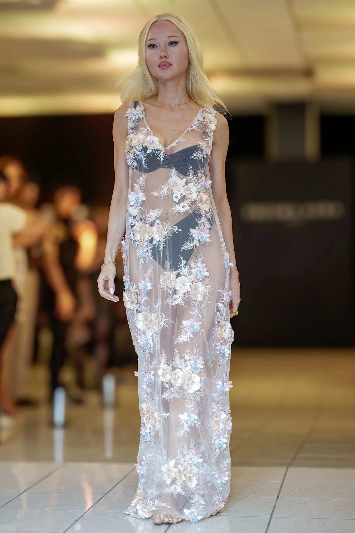 Model wearing Petal Mist by Preema Aura, sheer embroidered floral silk maxi dress in pastel tones, high-end runway fashion London.