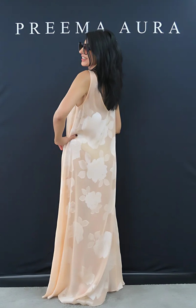 Back view of Preema Aura Soul Series Bloom dress – elegant sheer silk maxi in pale peach with large ivory floral motif and flowing silhouette
