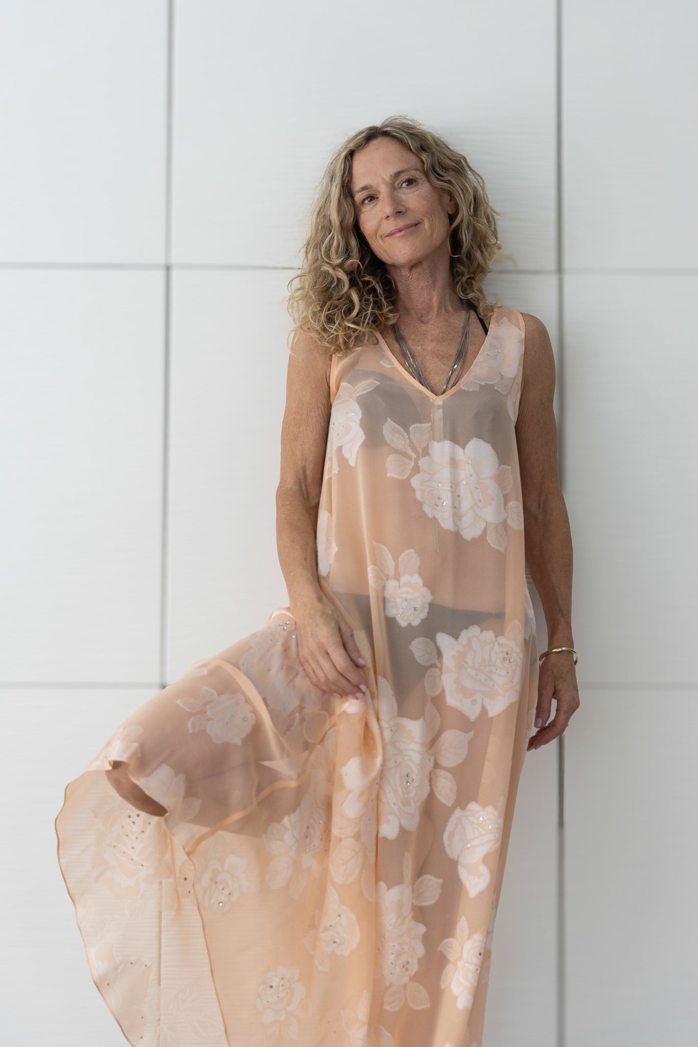 Soul Bloom by Preema Aura worn over a black bikini, showcasing the sheer peach floral fabric and lightweight movement.