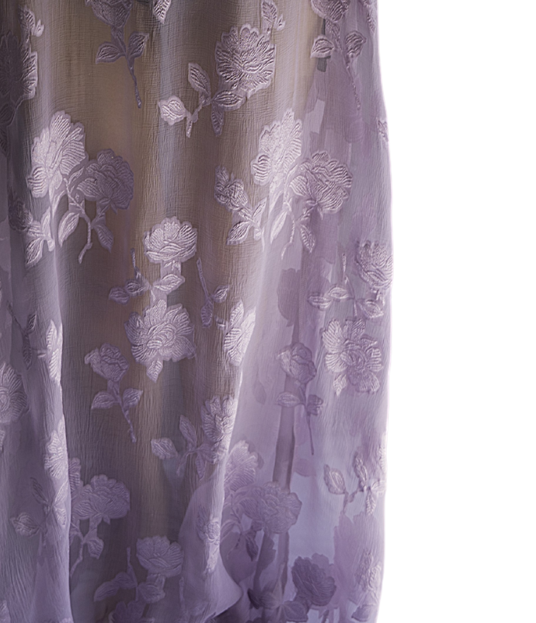 Model wearing a Preema Aura dress from the Soul Series – a flowing, floor-length gown designed for effortless elegance, crafted in lightweight sheer, lilac fabric with floral pattern, for luxury resort wear and timeless occasion dressing.