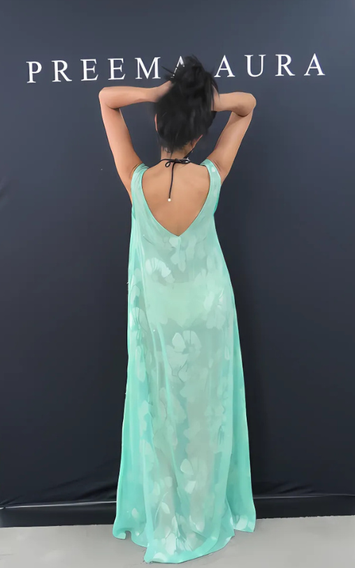 Back view of model wearing Preema Aura Soul Eden silk dress in mint green with sheer floral embroidery and a deep V-back.