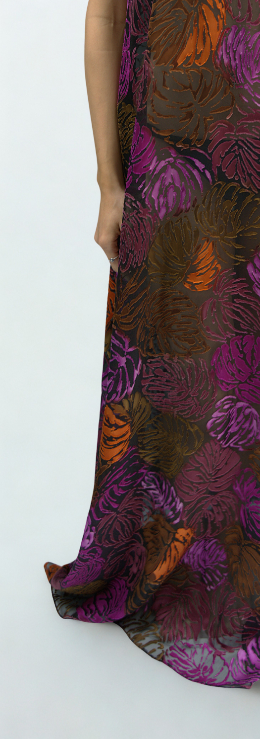 Close-up of Soul Flame dress fabric – sheer silk showcasing burnt orange, violet, and wine floral motifs with luxurious texture and fluid drape.