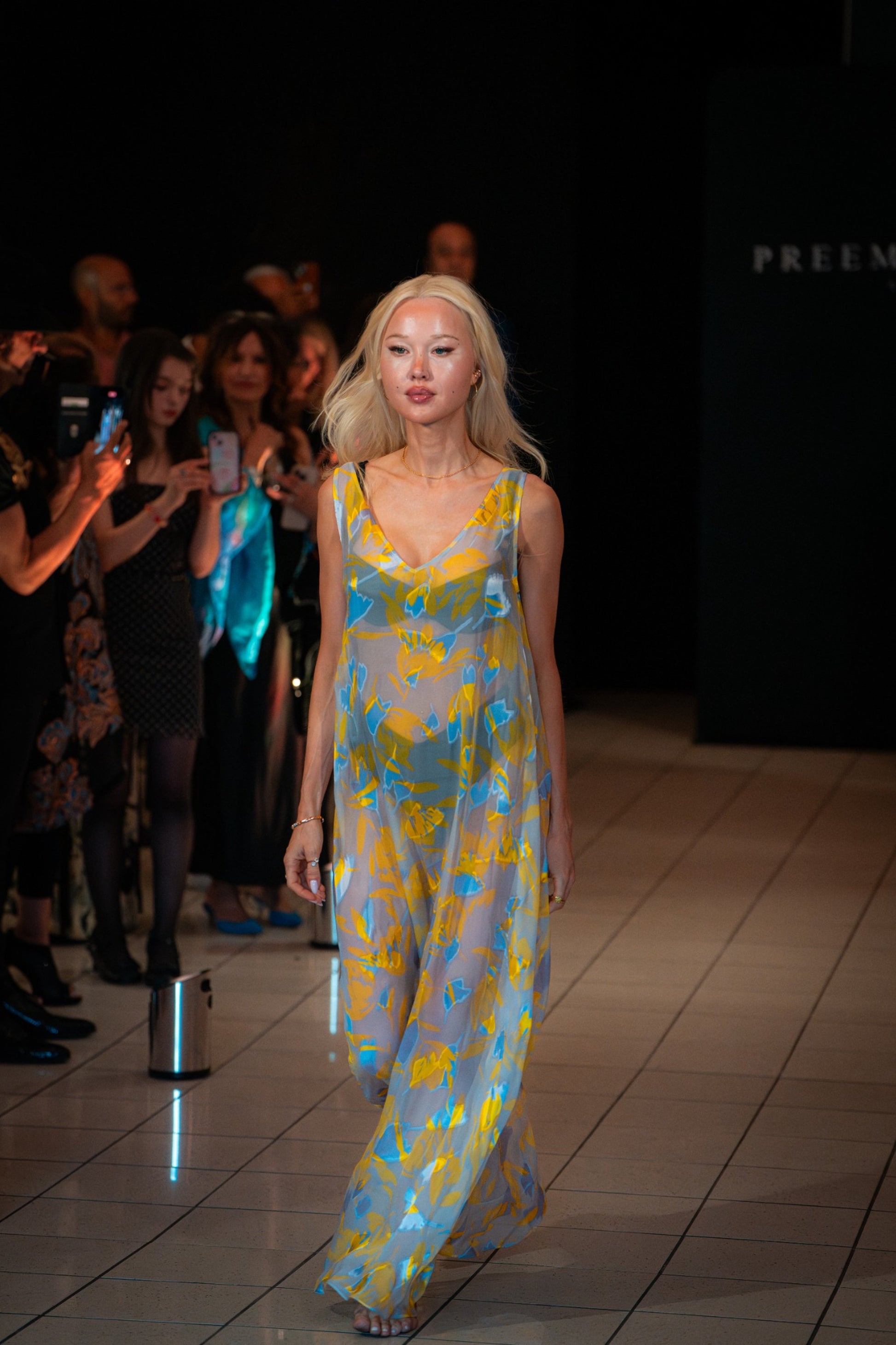 Model wearing the Soul Radiance dress by Preema Aura, a sheer silk chiffon gown in vibrant yellow and blue tones, showcased on the Park Lane runway.