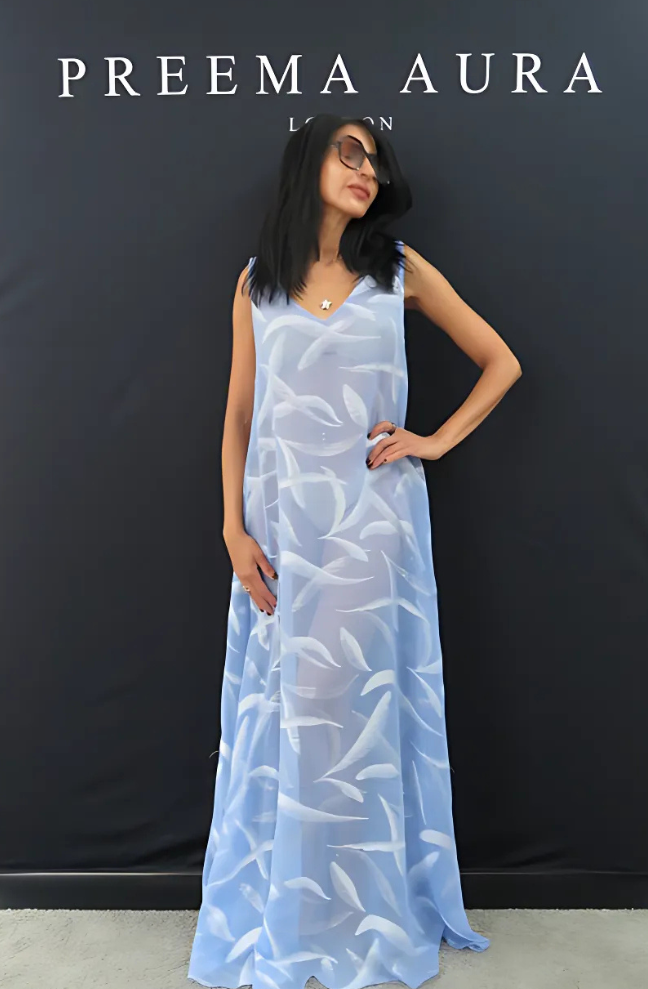 Model wearing Preema Aura Soul Soar silk dress in sky blue with white feather-inspired pattern – lightweight luxury resort wear photographed front-facing.