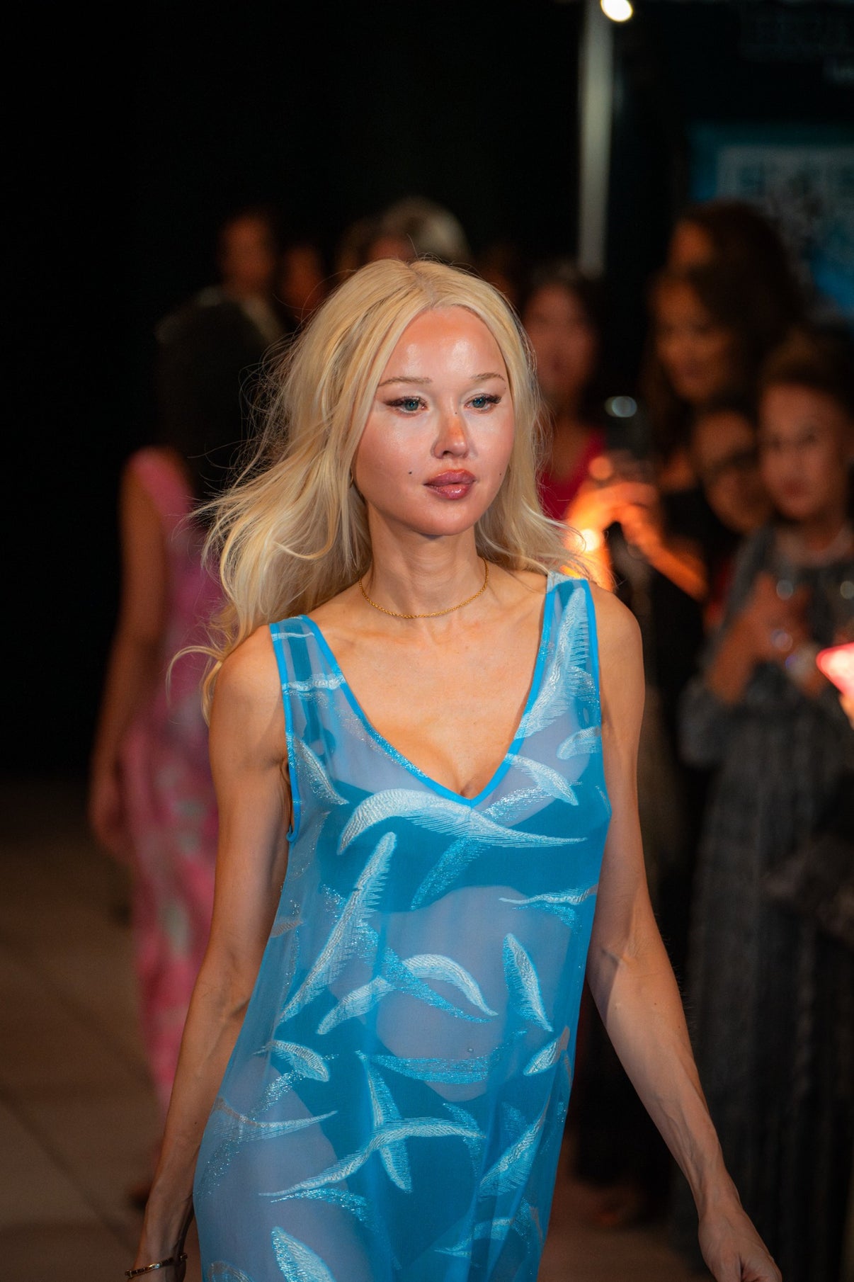 Model wearing the Soul Soar dress by Preema Aura, a sheer ocean-blue gown with shimmering feather-like motifs, captured on the Park Lane runway.