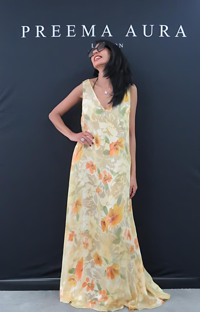 Model wearing Preema Aura Soul Series Solstice dress – lightweight silk gown with V neckline and a flowing silhouette in soft yellow with vibrant botanical accents