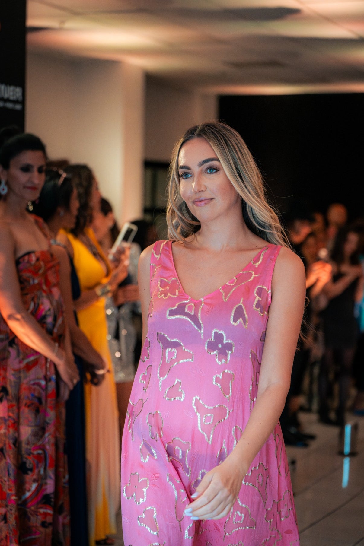 Model wearing the Soul Spark dress by Preema Aura, a vibrant fuchsia pink gown with shimmering gold accents, showcased during the Park Lane runway event.