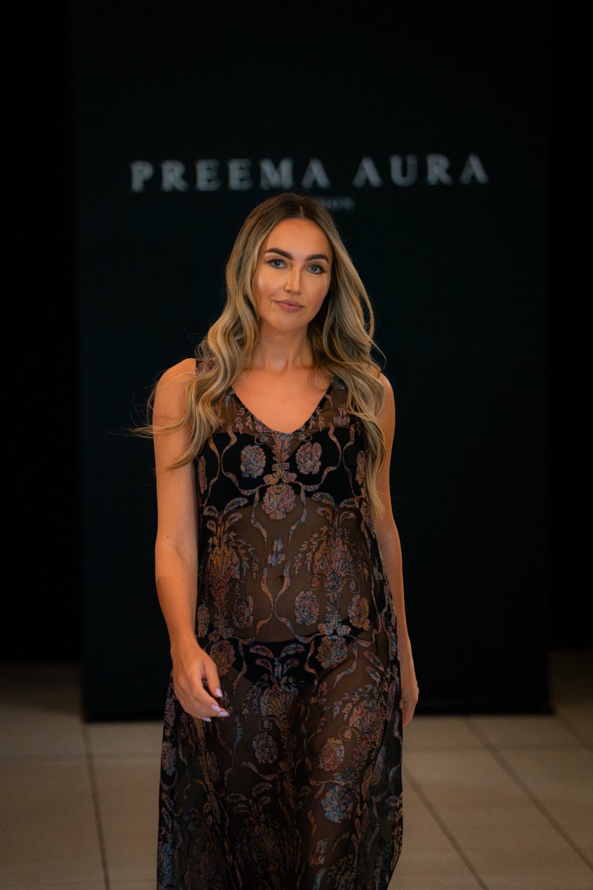Model wearing the Soul Sway dress by Preema Aura, a sheer black gown adorned with intricate floral detailing, unveiled on the Park Lane runway.