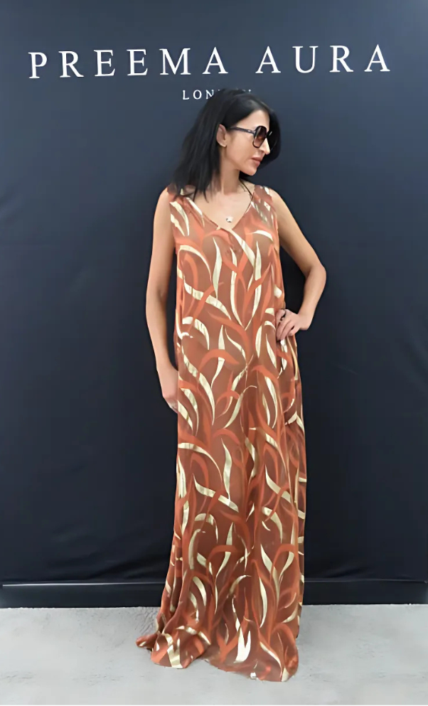Model wearing the Soul Terra dress by Preema Aura in copper silk, featuring fluid lines and gilded detailing, front view