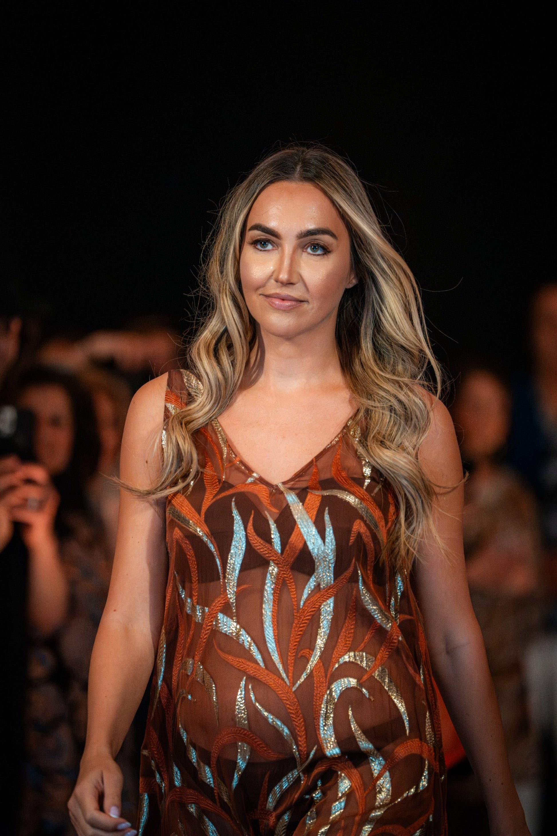 Model wearing the Soul Terra dress by Preema Aura, a sheer bronze gown with metallic leaf-inspired embroidery, walking the runway at the Park Lane launch.