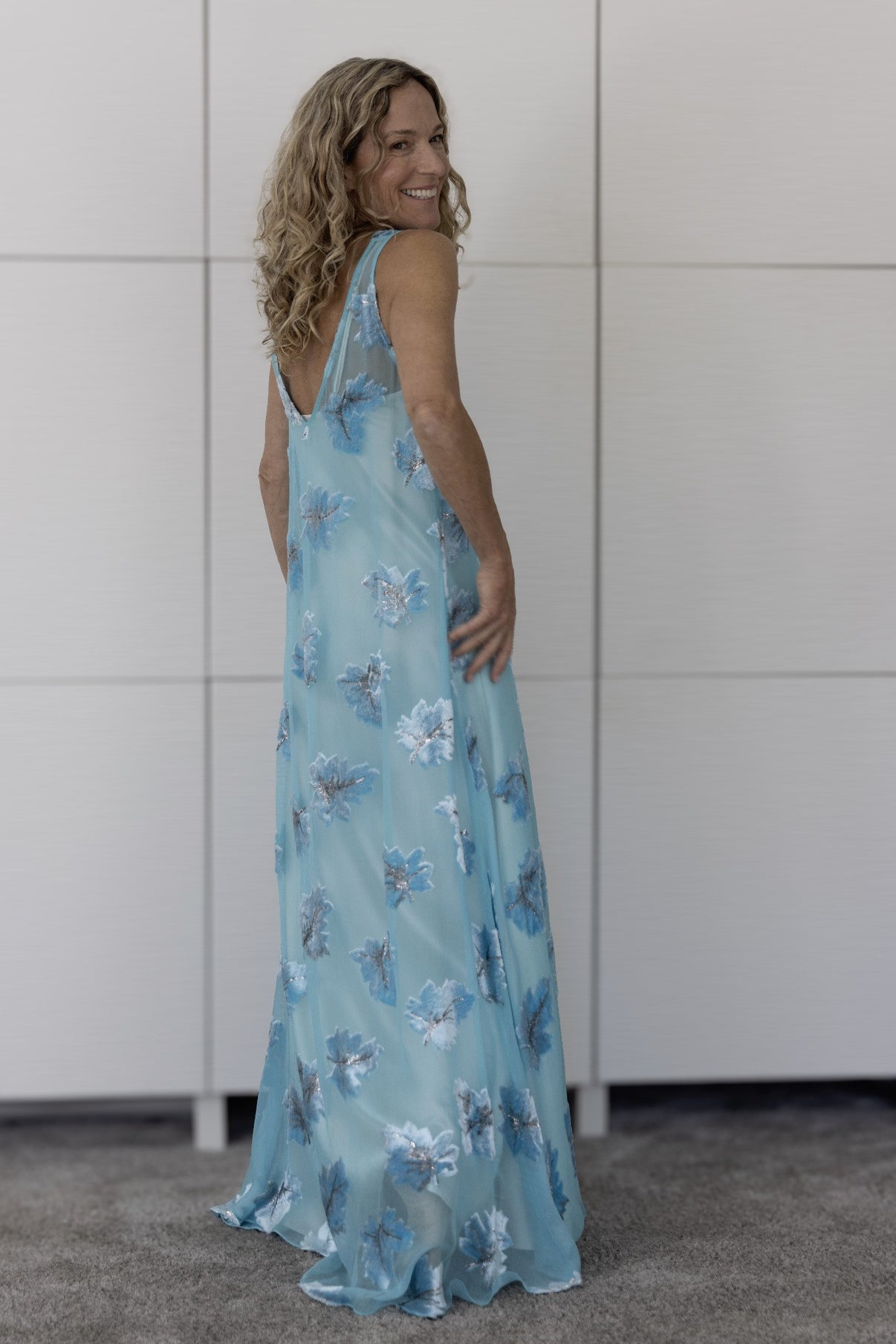 Back view of Preema Aura Soul Cascade dress over cream slip, highlighting fluid silhouette and hand-finished floral details