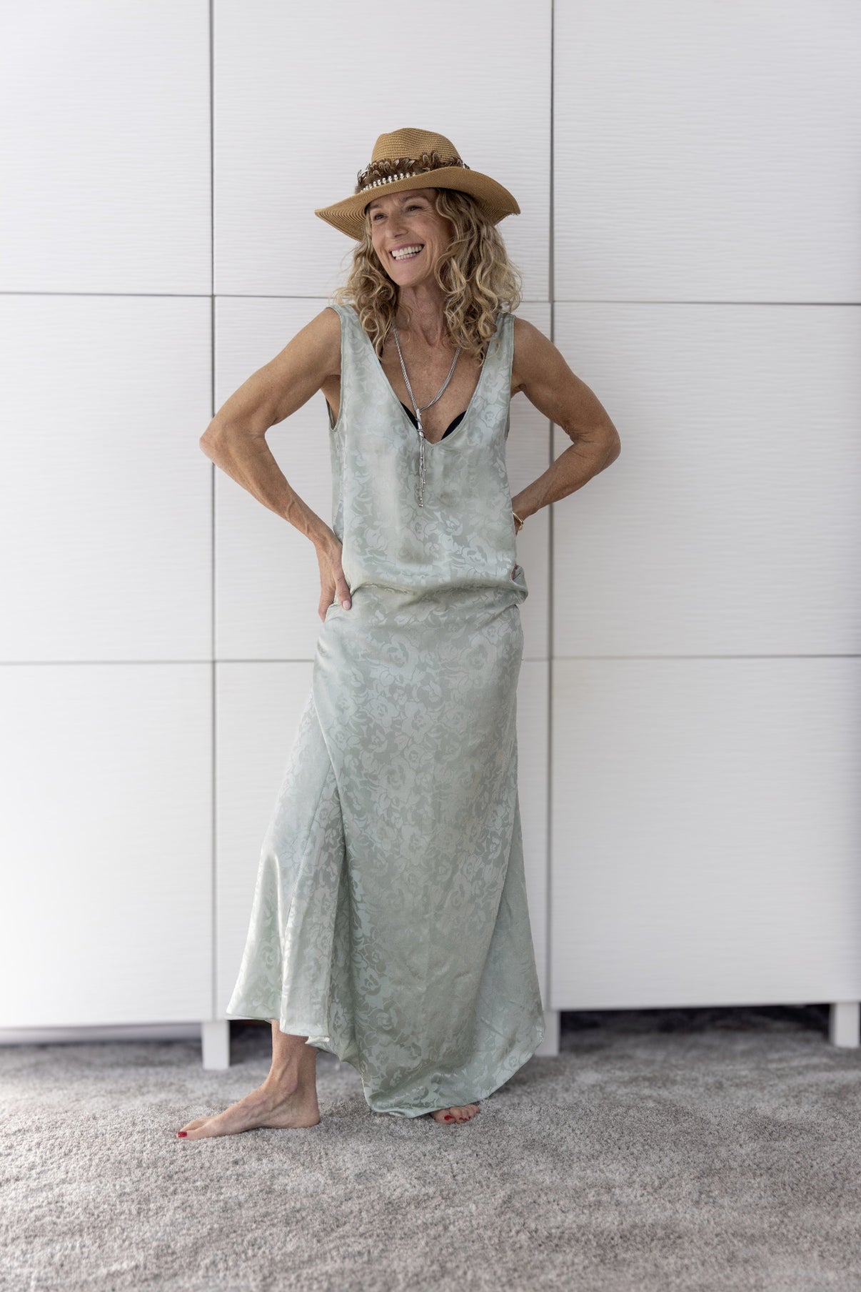 Woman wearing the Preema Aura Soul Mist sage green silk maxi dress, hand-tailored in London, capturing effortless resortwear elegance from the Soul Series.