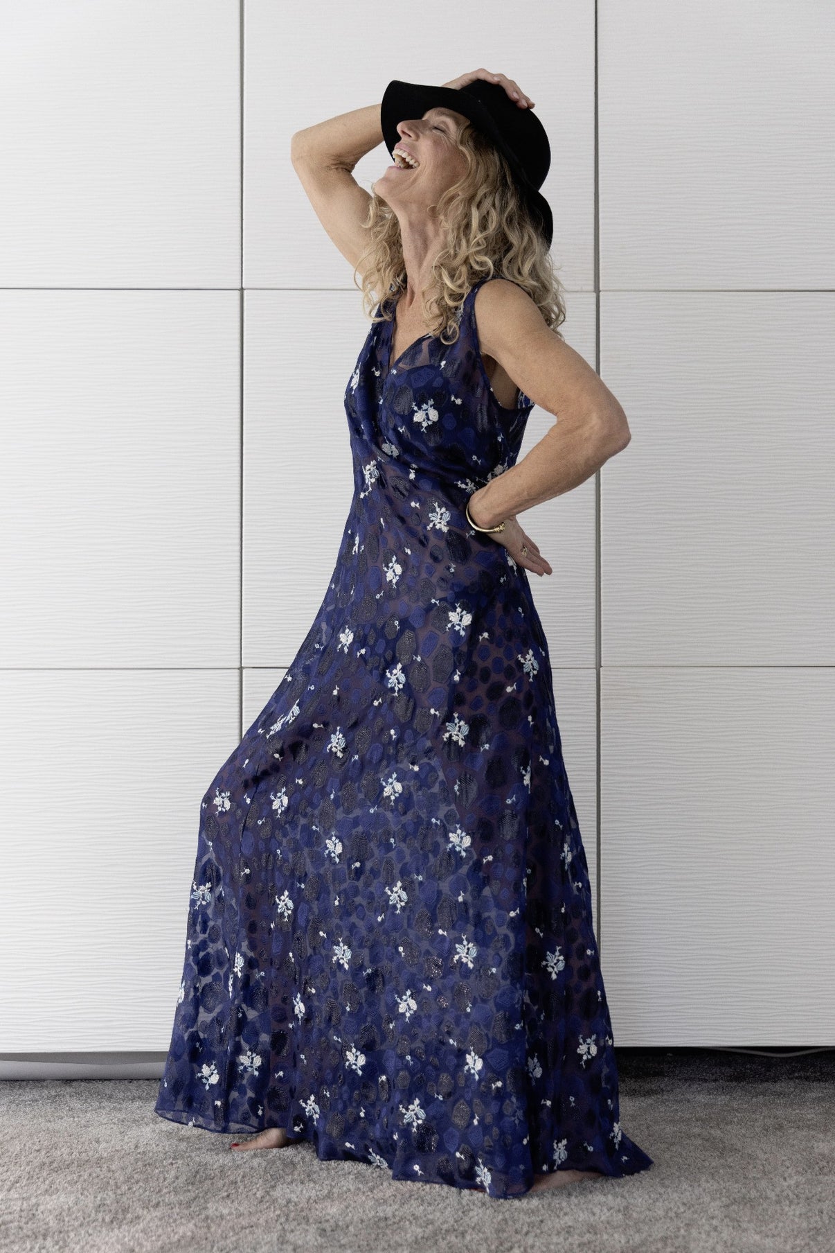 Woman laughing in elegant navy sheer Preema Aura Soul Nightfall dress with delicate floral detailing, luxury resortwear made in London