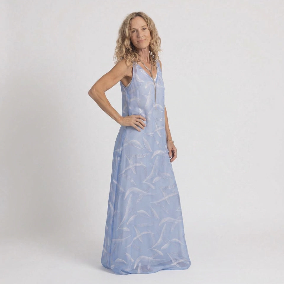Model wearing the Preema Aura Soul Soar sheer blue maxi dress over a cream satin slip, showing the soft movement and flow of the fabric